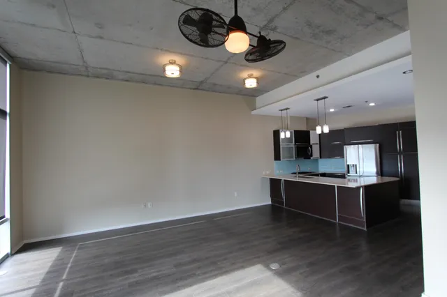 a view of a room with wooden floor and a ceiling fan