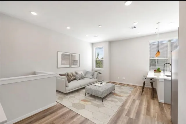 a living room with furniture and a wooden floor