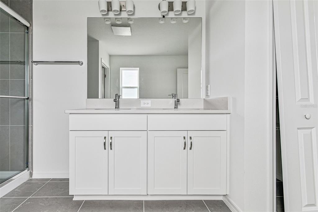 9106 Optimist Way Palmetto, FL 34221 - Photo 14 of 28 a bathroom with a sink vanity and a mirror