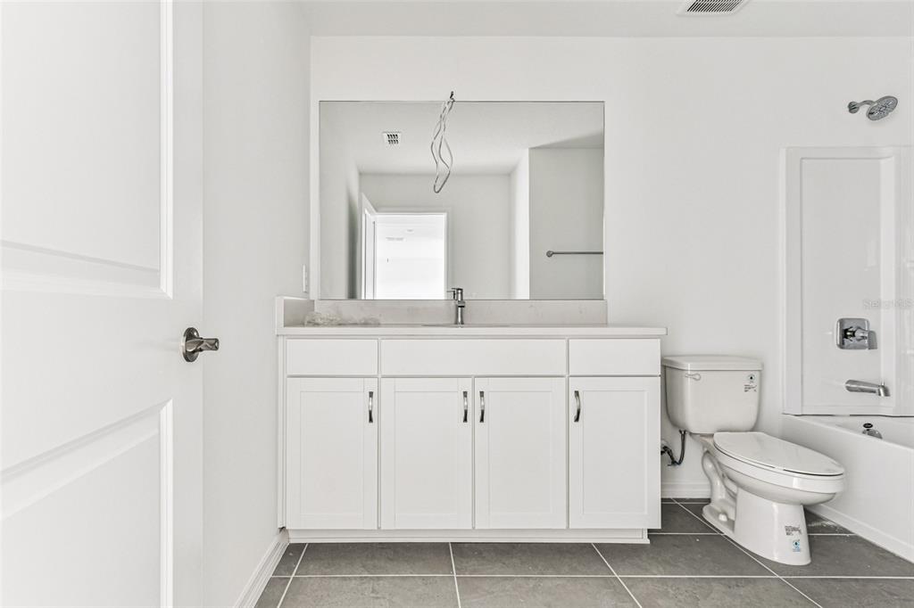 9106 Optimist Way Palmetto, FL 34221 - Photo 22 of 28 a bathroom with a toilet a sink and a mirror