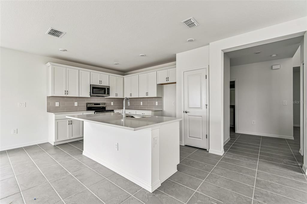 9106 Optimist Way Palmetto, FL 34221 - Photo 6 of 28 a kitchen with white cabinets appliances and sink