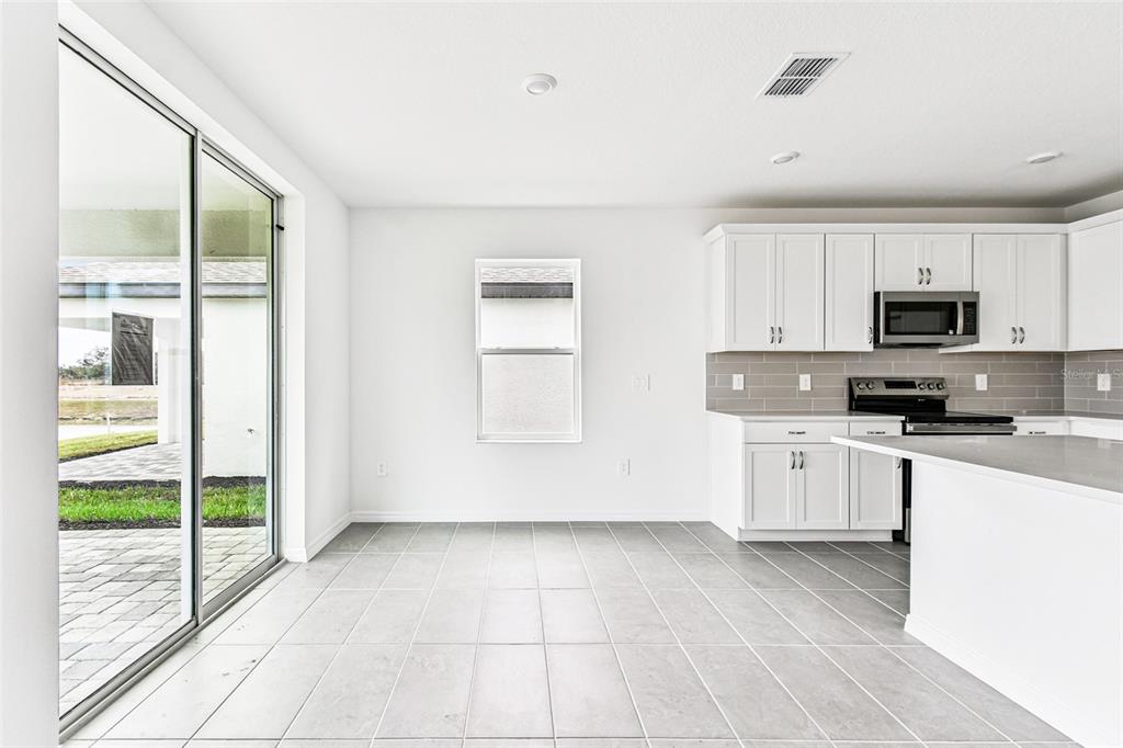 9106 Optimist Way Palmetto, FL 34221 - Photo 9 of 28 a kitchen with stainless steel appliances a refrigerator sink and cabinets