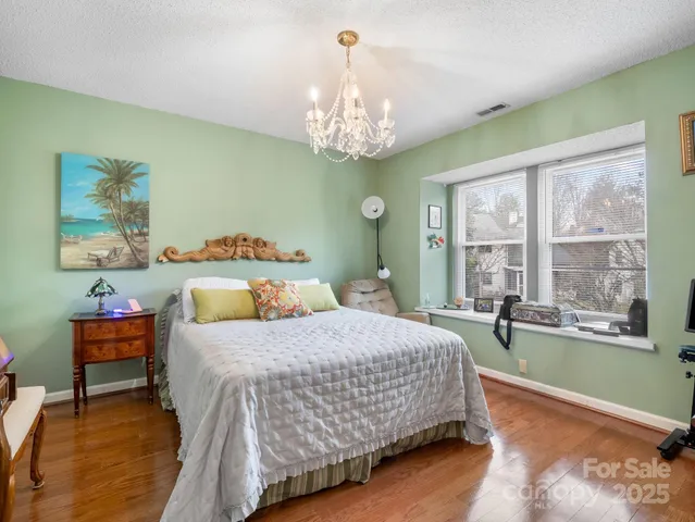 a bedroom with a bed and a chandelier