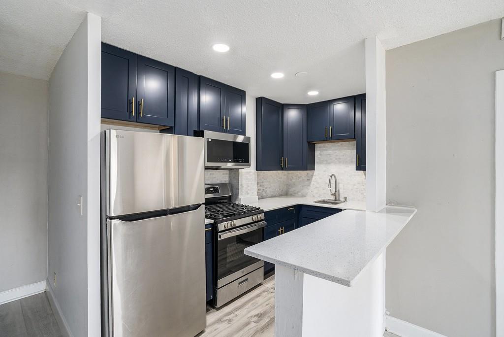 a kitchen with stainless steel appliances cabinets a sink and a refrigerator