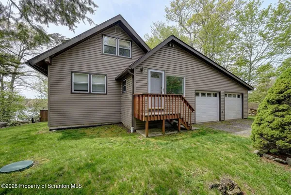 a view of a house with a yard and deck area
