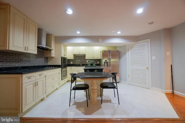 a kitchen with stainless steel appliances granite countertop a stove a sink and a refrigerator