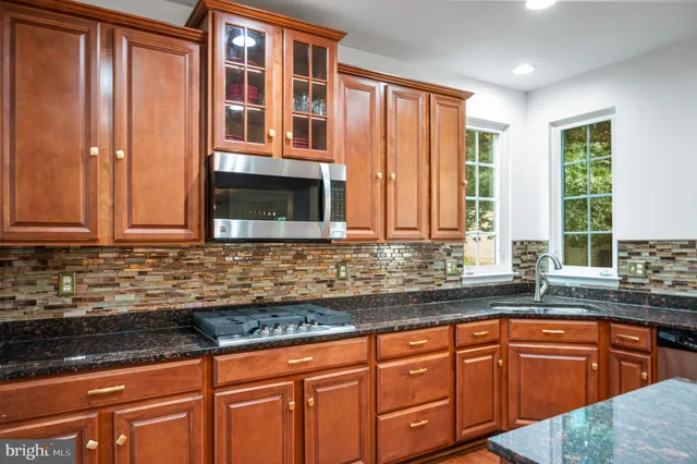 a view of a hallway with wooden floor and a bathroom