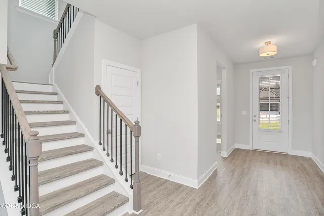 a view of a hallway with wooden floor and entryway