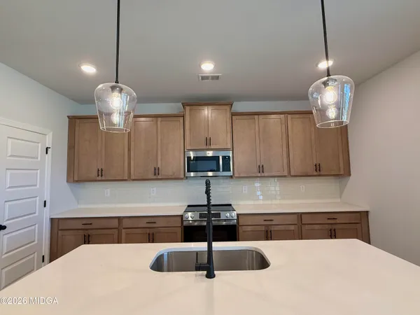 a kitchen with sink refrigerator and cabinets