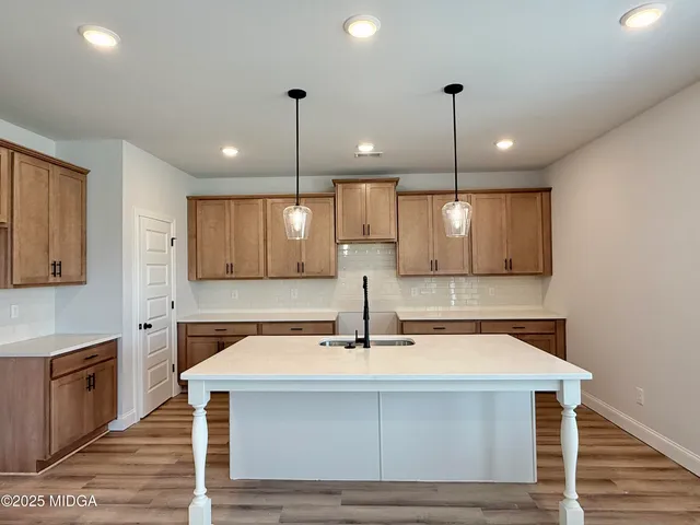 a view of a kitchen center island sink and cabinets