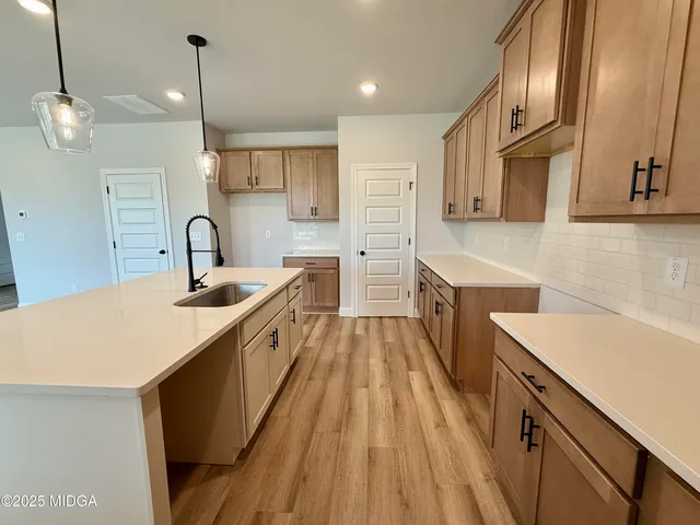 a large kitchen with stainless steel appliances kitchen island a large counter top a sink a stove and a refrigerator