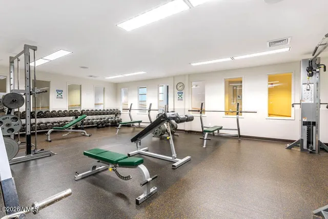 a room with gym equipment and windows