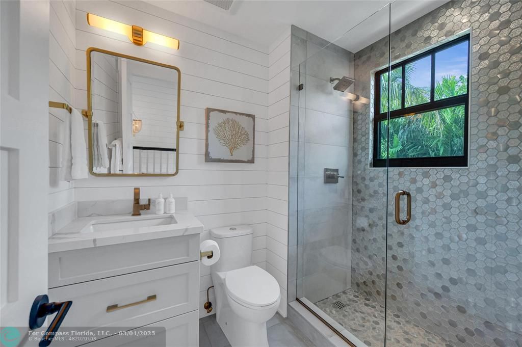 450 North Swinton Avenue Delray Beach, FL 33444 - Photo 38 of 43 a bathroom with a toilet sink vanity and mirror