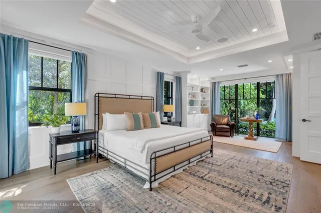 a bedroom with a bed and large windows