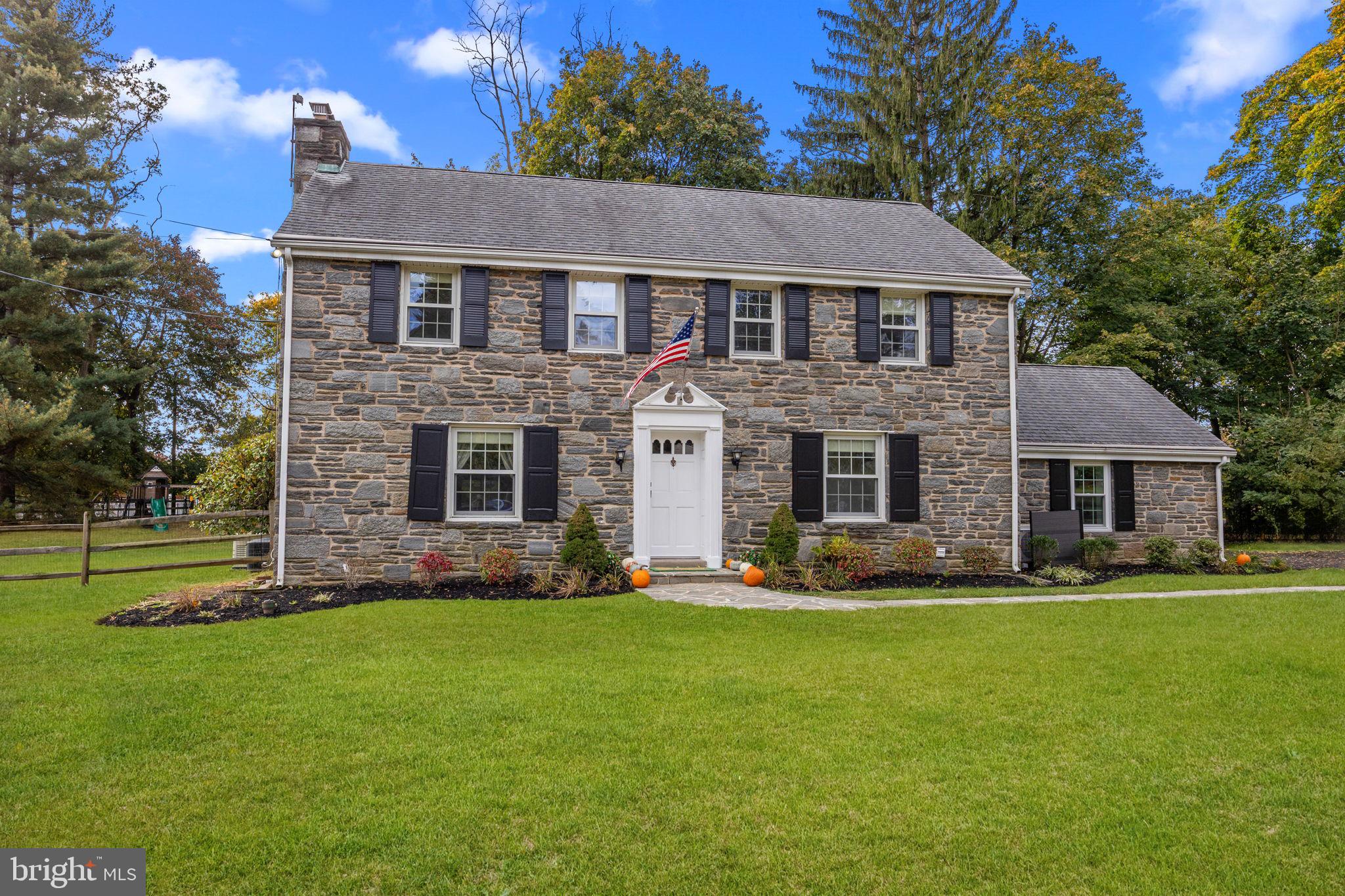 a front view of a house with a yard and trees