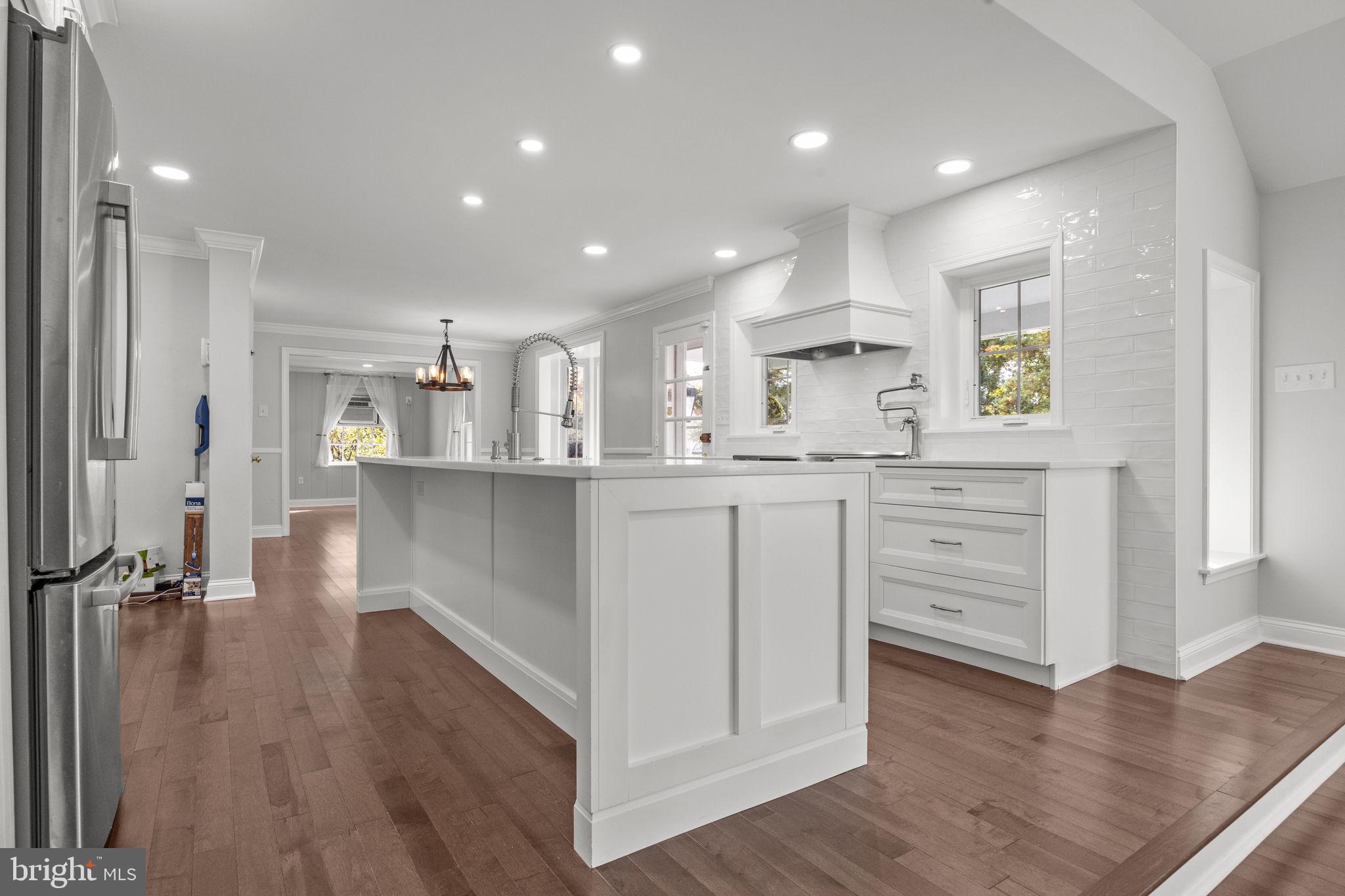 1434 Holcomb Road Huntingdon Valley, PA 19006 - Photo 14 of 49 a kitchen with stainless steel appliances kitchen island granite countertop a refrigerator a sink and white cabinets with wooden floor