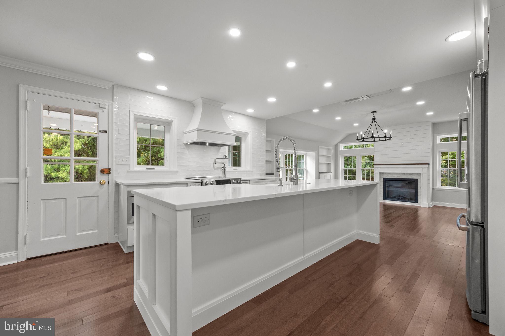 1434 Holcomb Road Huntingdon Valley, PA 19006 - Photo 18 of 49 a open kitchen with kitchen island a sink dishwasher a stove and a refrigerator with wooden floor