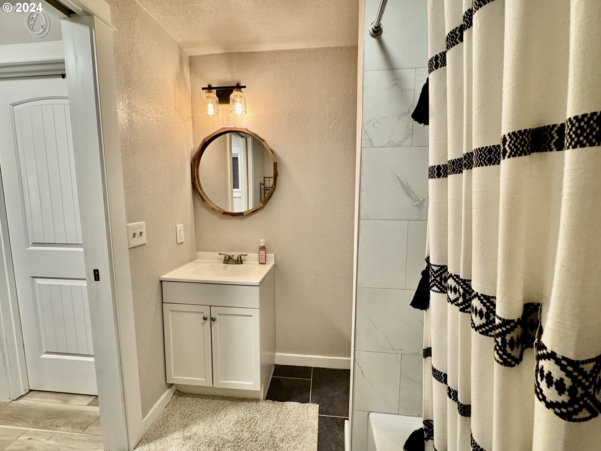 363 57th Street Springfield, OR 97478 - Photo 8 of 19 a bathroom with a sink a mirror and a shower