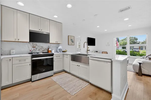 a kitchen with granite countertop white cabinets and white appliances