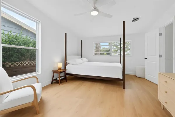 a bedroom with a bed window and a flat tv screen
