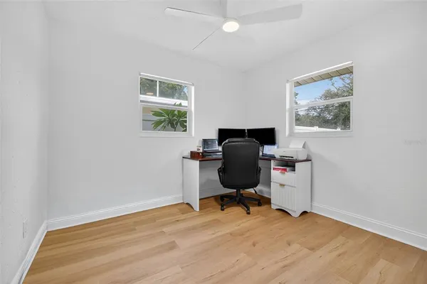 a view of workspace with wooden floor and a window