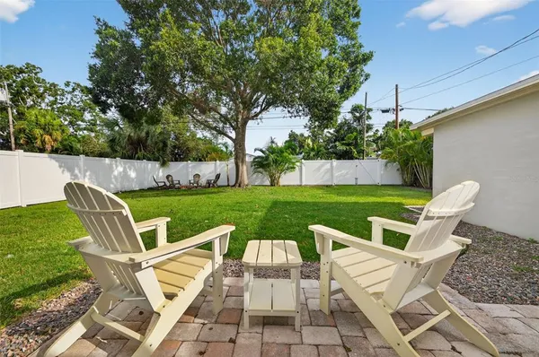 a view of a chairs and table in backyard of the house