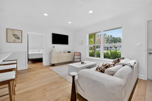 a living room with furniture a flat screen tv and a large window