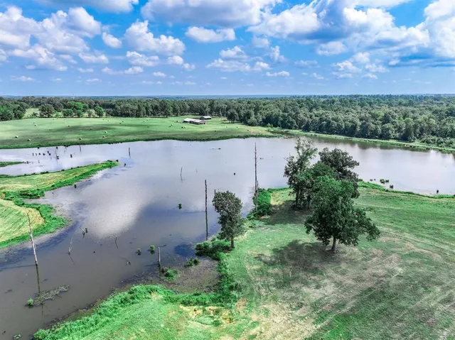 an aerial view of a house with a yard and lake view in back