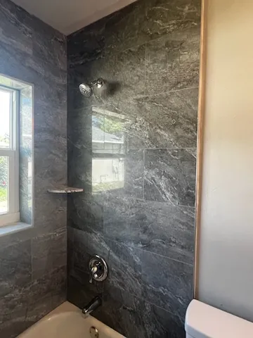 a bathroom with a toilet and a shower