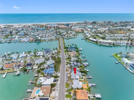 an aerial view of ocean and residential houses with outdoor space