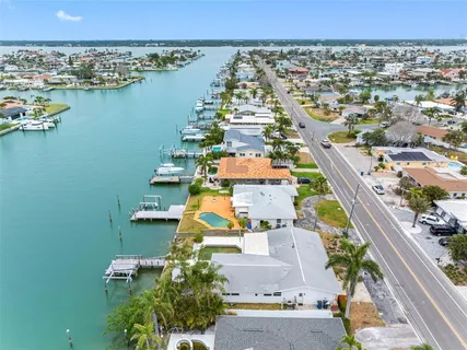 an aerial view of ocean and residential houses with outdoor space