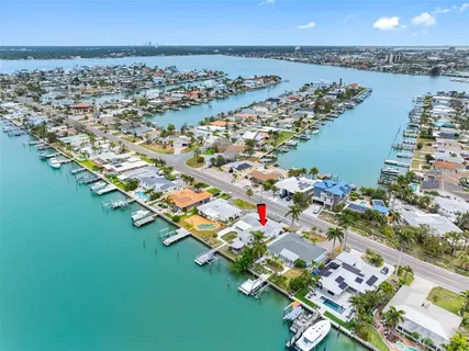 an aerial view of ocean and residential houses with outdoor space
