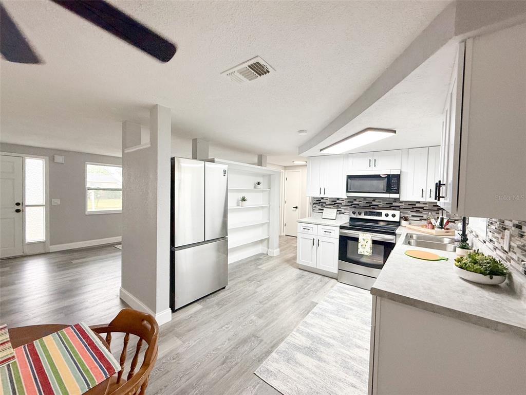 10805 Fillmore Avenue Port Richey, FL 34668 - Photo 11 of 32 a kitchen with a refrigerator and a stove top oven