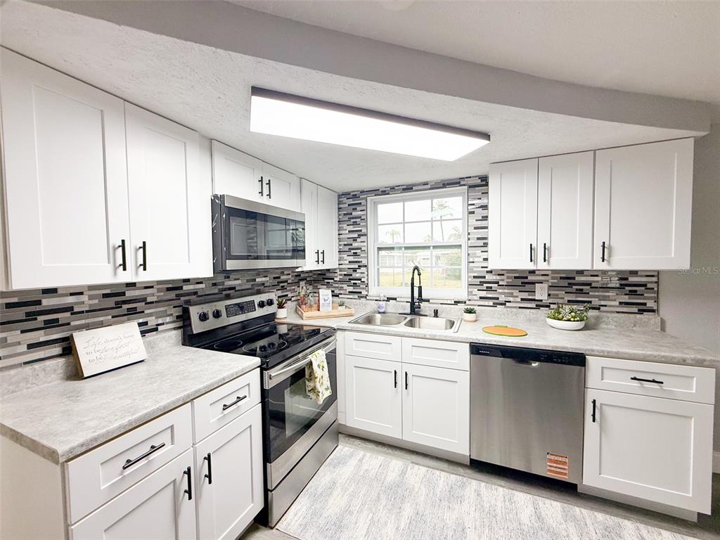 10805 Fillmore Avenue Port Richey, FL 34668 - Photo 12 of 32 a kitchen with white cabinets and white appliances