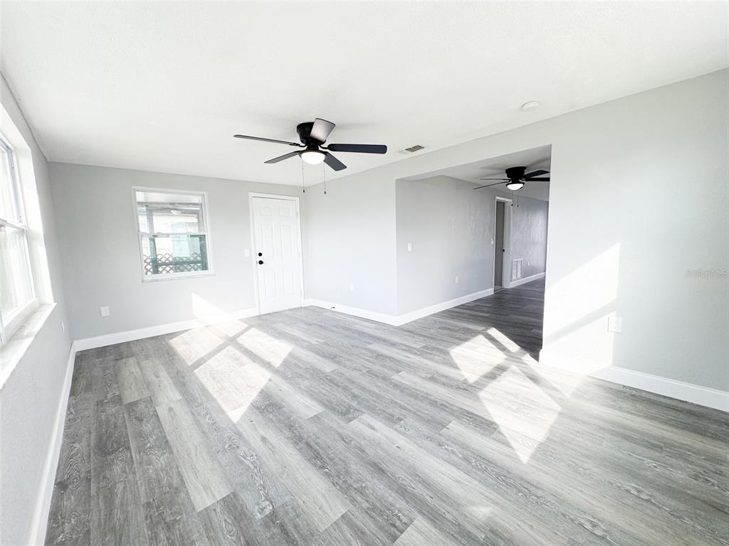 10805 Fillmore Avenue Port Richey, FL 34668 - Photo 14 of 32 a view of empty room with wooden floor and fan
