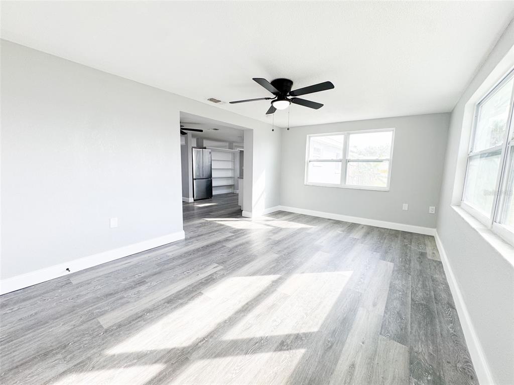 10805 Fillmore Avenue Port Richey, FL 34668 - Photo 16 of 32 a view of empty room with wooden floor and fan