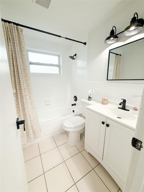 10805 Fillmore Avenue Port Richey, FL 34668 - Photo 17 of 32 a bathroom with a sink a toilet and mirror