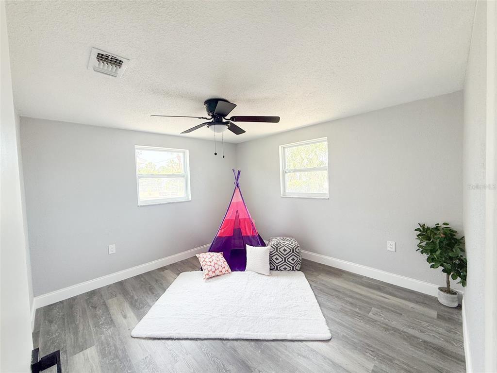 10805 Fillmore Avenue Port Richey, FL 34668 - Photo 27 of 32 a living room with a couch and wooden floor