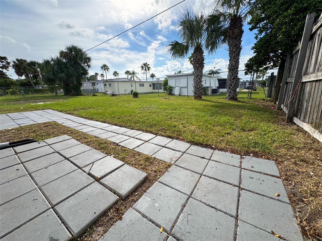 10805 Fillmore Avenue Port Richey, FL 34668 - Photo 30 of 32 a view of a yard with plants and palm trees