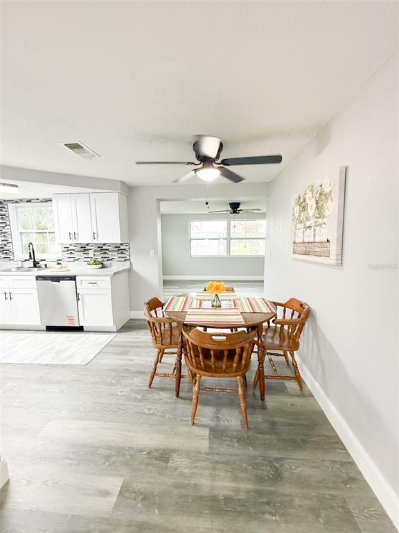 10805 Fillmore Avenue Port Richey, FL 34668 - Photo 9 of 32 a dining room with a wooden table and chairs