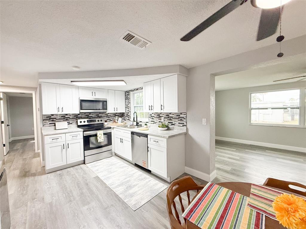 10805 Fillmore Avenue Port Richey, FL 34668 - Photo 10 of 32 a kitchen with granite countertop appliances cabinets and a rug