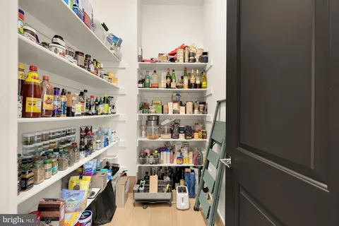 a large white kitchen with a large window and furniture