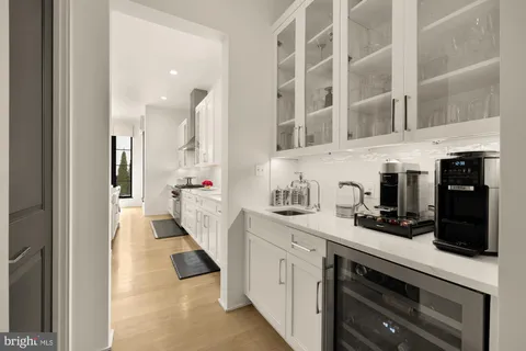 a large white kitchen with a large window and furniture