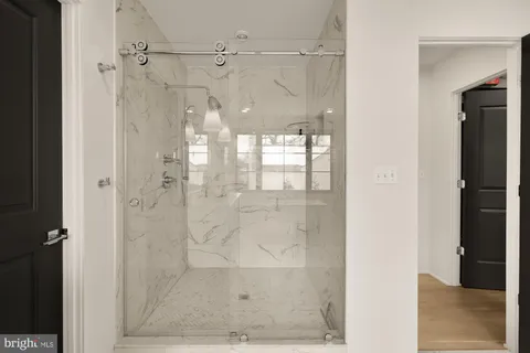 a bathroom with a granite countertop sink a toilet a mirror a bathtub and shower