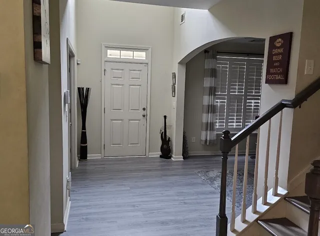 a view of a hallway with wooden floor and staircase