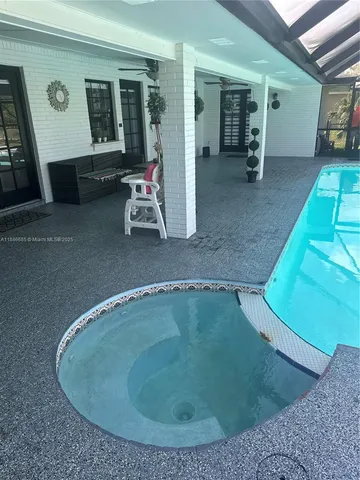 a kitchen with granite countertop a sink stainless steel appliances white cabinets and a window
