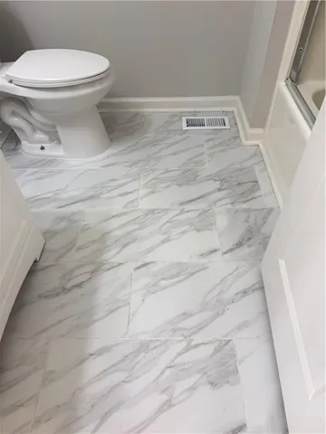 a bathroom with a toilet and a shower