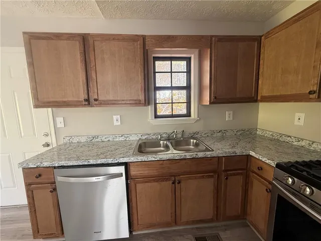 a kitchen with stainless steel appliances granite countertop a sink stove and cabinets