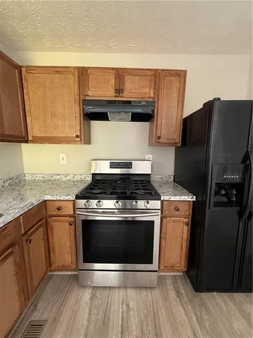 a kitchen with stainless steel appliances granite countertop a stove and a refrigerator