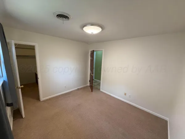 an empty room with an entryway and fan